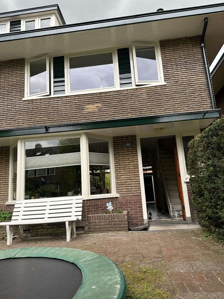Voorgevel van een jaren-30 woning met erker en geschilderde kozijnen