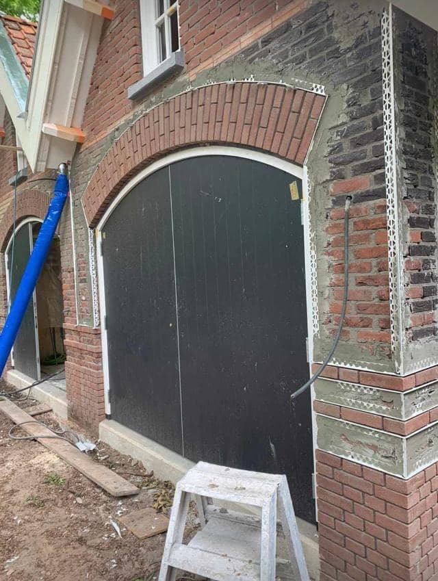 Dubbele boogdeuren van het koetshuis tijdens het werk aan de gevel